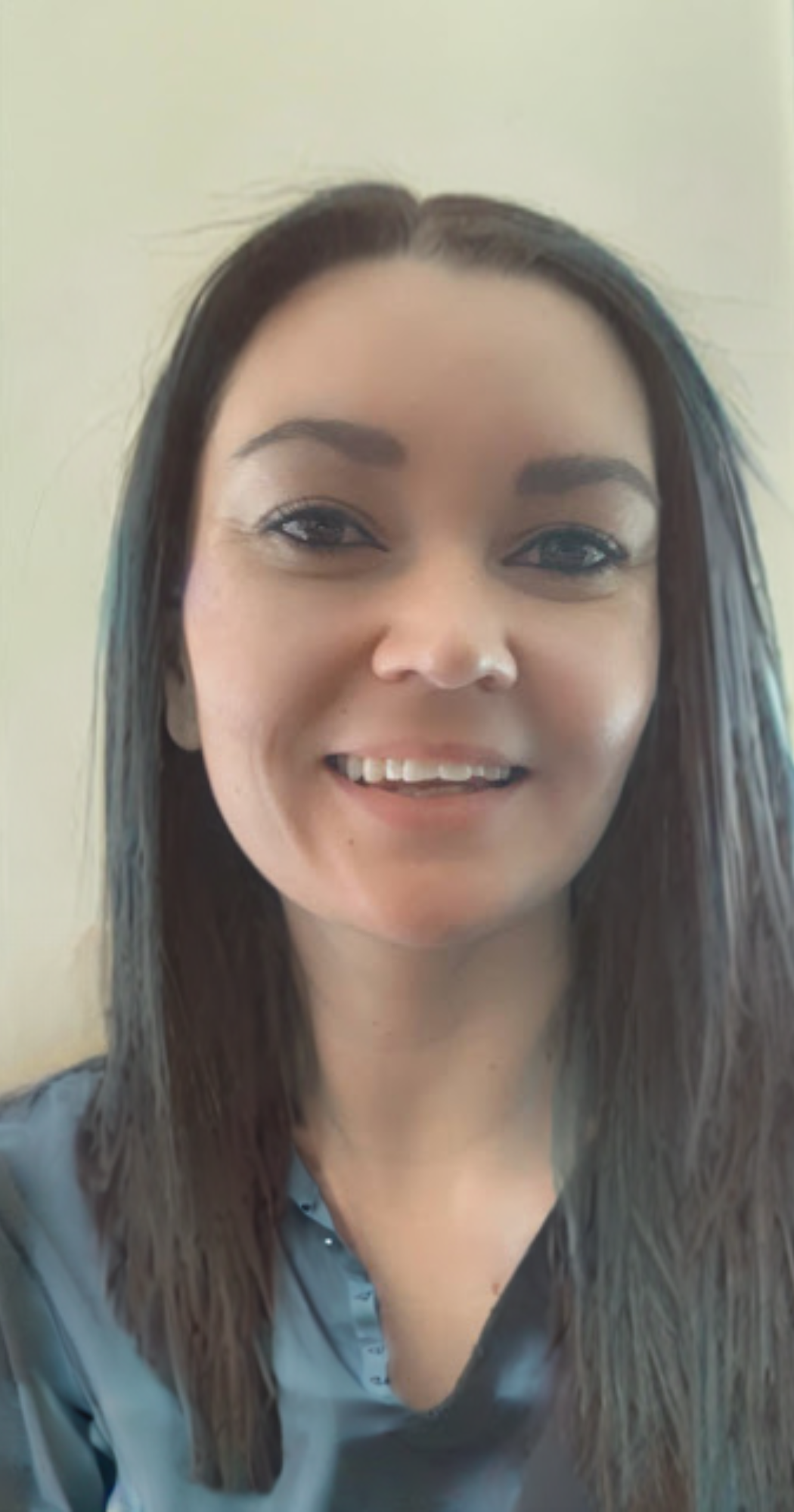 Brandy the office manager at bauman endodontics smiling with long hair 